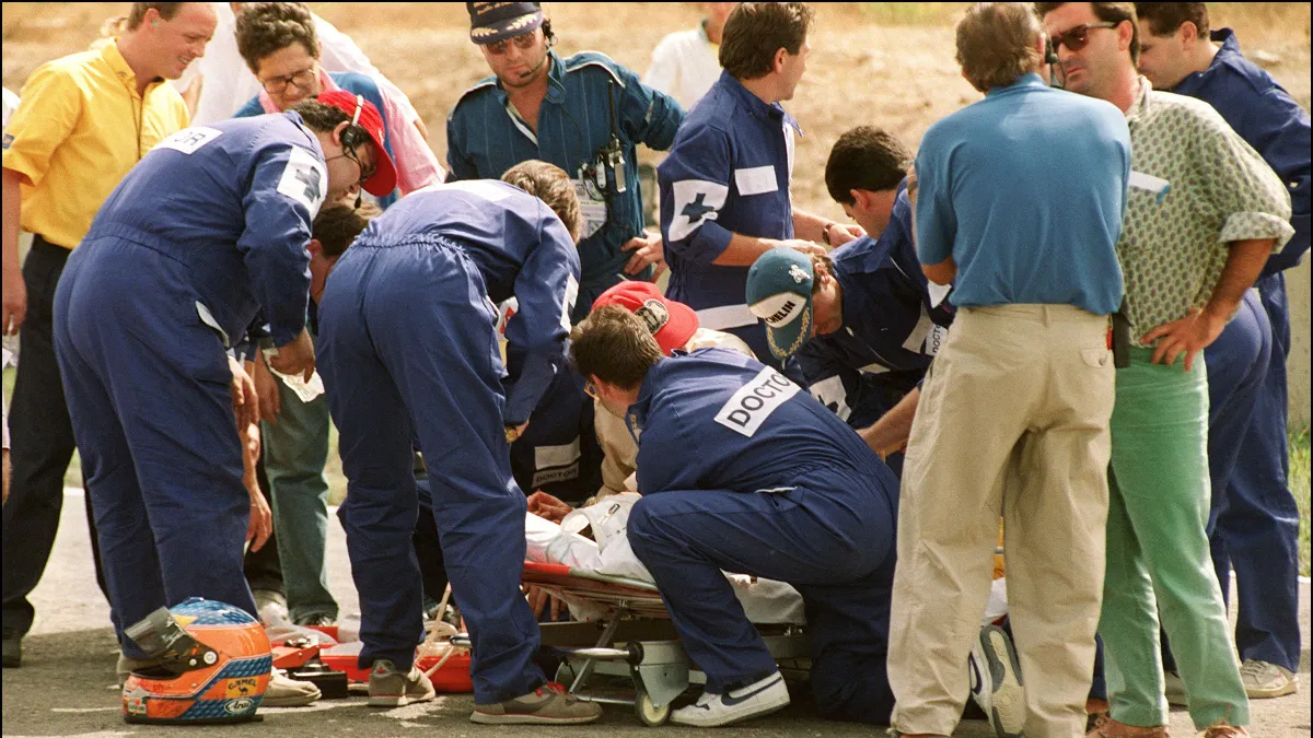 Lewis Hamilton, Medical personnel surround British driver Martin Donnelly after his car crashed 28 September 1990 at Jerez race track, during the first training session of Spanish Grand Prix. (Photo by JEAN-LOUP GAUTREAU / AFP)