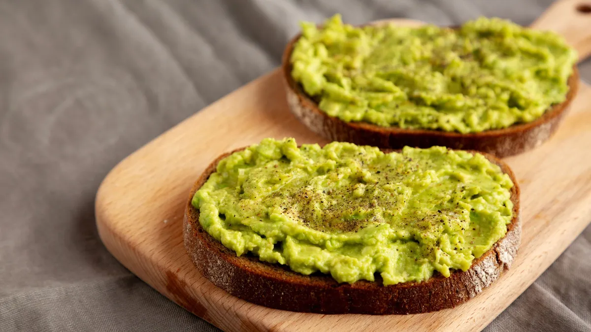 zsírmáj,  Homemade Avocado Toast with Salt and Pepper on a wooden board, side view.