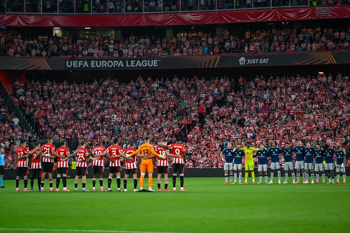 Players stand for a minute of silence before the UEFA Europa League semi final first leg football match between Athletic Club Bilbao and Manchester United at the San Mames stadium in Bilbao, on May 1, 2025. (Photo by ANDER GILLENEA / AFP), Athletic Bilbao