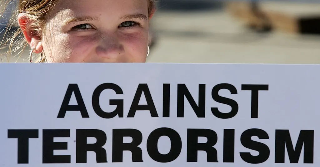 terrortámadás A girl with an anti terror poster attends a vigil in Trafalgar Square in London, 14 July 2005 for the victims of the four suicide bombings in the British capital on the 7th July. AFP PHOTO/PACO SERINELLI (Photo by PACO SERINELLI / AFP)