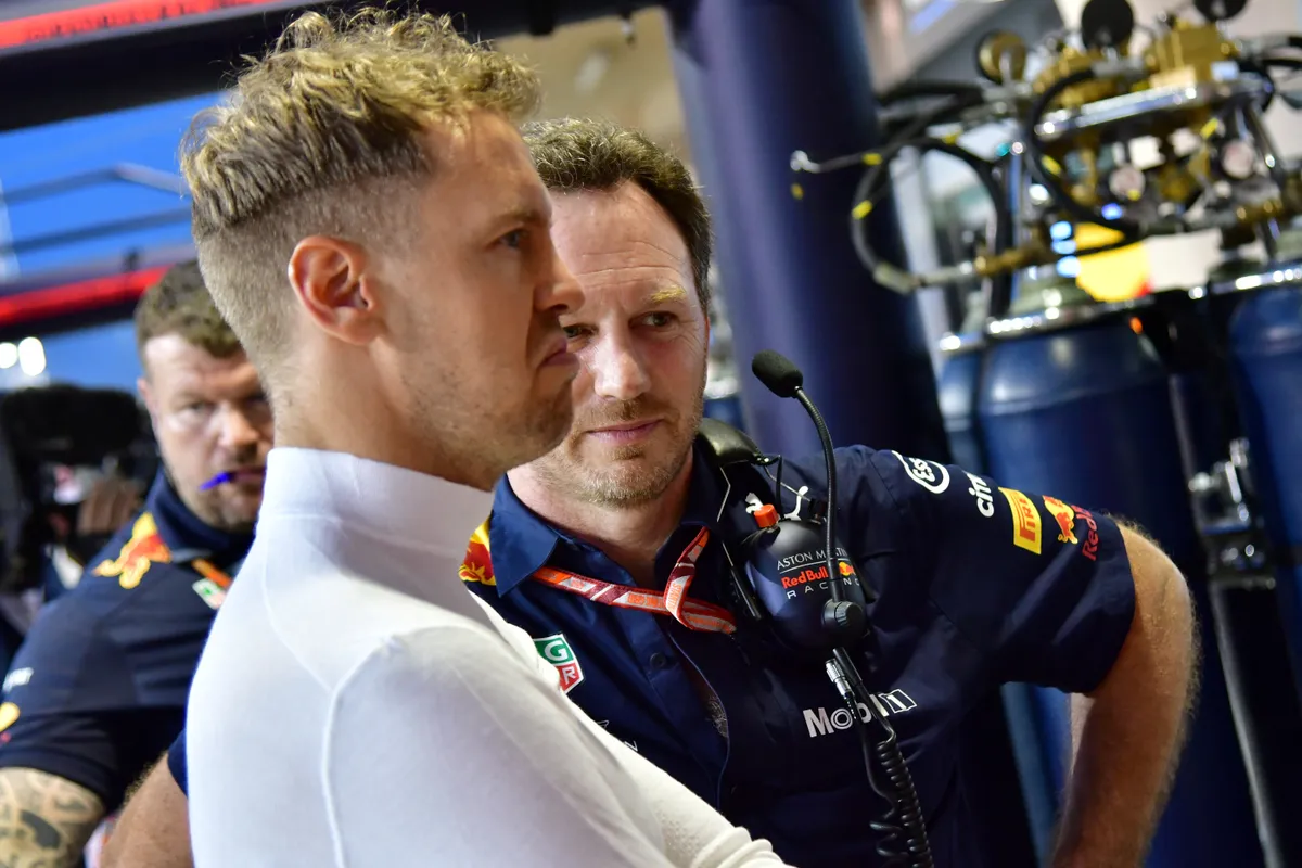(FILES) Red Bull's team principal Christian Horner (R) talks to Ferrari's German driver Sebastian Vettel (L) in the pit lane during the second practice session ahead of the qualifiers for the Bahrain Formula One Grand Prix at the Sakhir circuit in Manama on April 6, 2018. Christian Horner is to leave his role as Red Bull team principal with immediate effect after 20 years, the Formula One team announced on July 9, 2025. (Photo by GIUSEPPE CACACE / AFP)