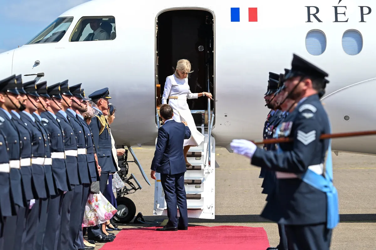 France's President Emmanuel Macron and his wife Brigitte Macron disembark upon arrival at RAF Northolt, west of London, on July 8, 2025, on the first day of a three-day state visit to Britain. French President Emmanuel Macron begans a three-day state visit to Britain on July 8, 2025, which will see him address parliament and try to rekindle a purportedly warm relationship with King Charles III. (Photo by Jeanne ACCORSINI / POOL / AFP)