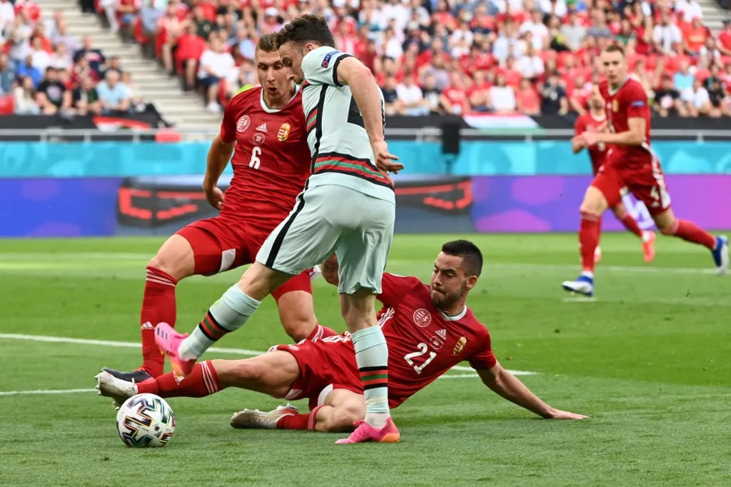 Portugal's forward Diogo Jota (C) is tackled by Hungary's defender Endre Botka beside Hungary's defender Willi Orban (L) during the UEFA EURO 2020 Group F football match between Hungary and Portugal at the Puskas Arena in Budapest on June 15, 2021. (Photo by Attila KISBENEDEK / POOL / AFP)