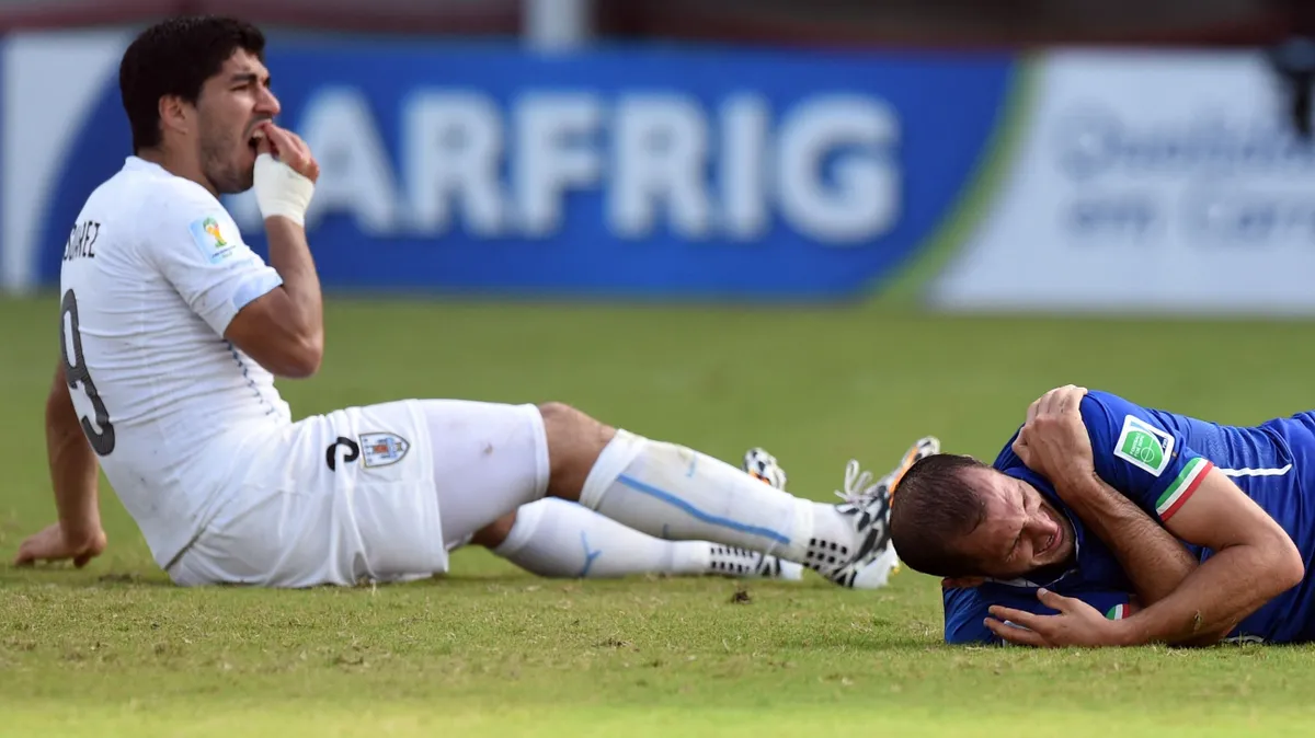 Uruguay's forward Luis Suarez (L) reacts past Italy's defender Giorgio Chiellini during a Group D football match between Italy and Uruguay at the Dunas Arena in Natal during the 2014 FIFA World Cup on June 24, 2014. AFP PHOTO/ JAVIER SORIANO (Photo by JAVIER SORIANO / AFP)