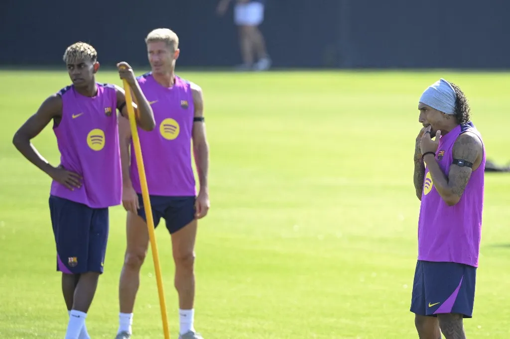 Barcelona's Brazilian forward #11 Raphinha (R) gives a finger whistle next to Barcelona's Polish forward #09 Robert Lewandowski (C) and Barcelona's Spanish forward #10 Lamine Yamal during a training session at the Joan Gamper training ground in Sant Joan Despi, near Barcelona, on July 17, 2025. (Photo by Josep LAGO / AFP)