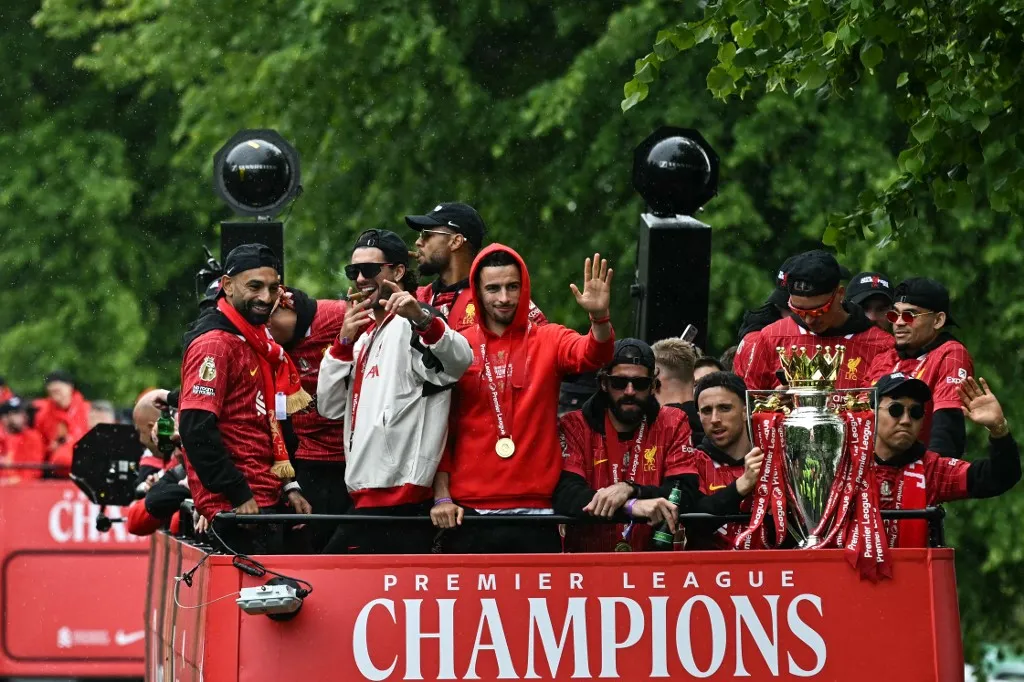 (From L) Liverpool's Egyptian striker #11 Mohamed Salah, Liverpool's Hungarian midfielder #08 Dominik Szoboszlai, Liverpool's English midfielder #17 Curtis Jones, Liverpool's Brazilian goalkeeper #01 Alisson Becker, Liverpool's Portuguese striker #20 Diogo Jota and Liverpool's Japanese midfielder #03 Wataru Endo celebrate with the Premier League trophy during an open-top bus victory parade for Liverpool's Premier League title win, in Liverpool, north-west England on May 26, 2025. (Photo by Paul ELLIS / AFP)