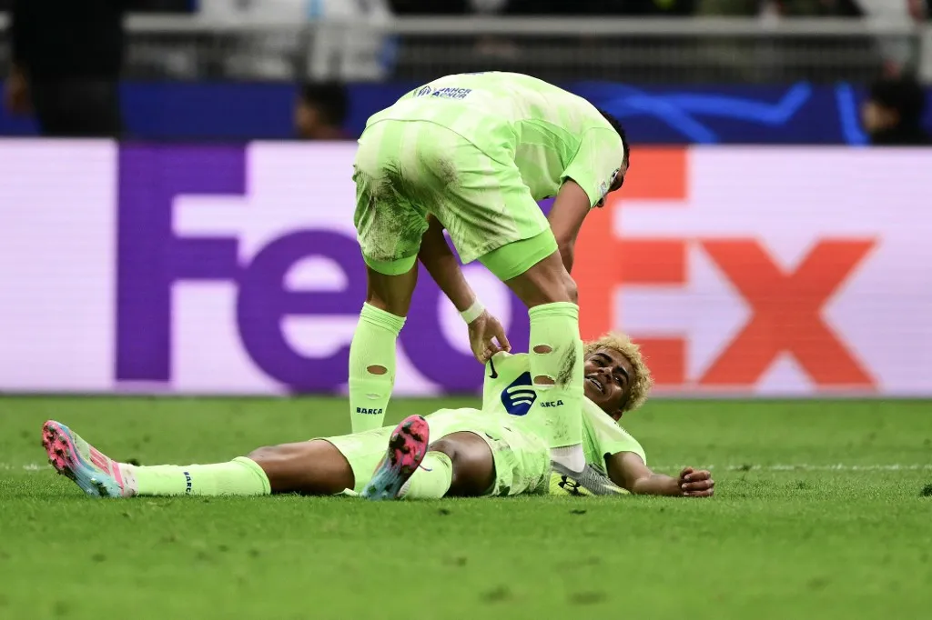 Barcelona's Spanish forward #19 Lamine Yamal (on ground) reacts after a tackle by Inter Milan's Armenian midfielder #22 Henrikh Mkhitaryan during the UEFA Champions League semi-final second leg football match between Inter Milan and FC Barcelona at the San Siro stadium in Milan on May 6, 2025. (Photo by Marco BERTORELLO / AFP)