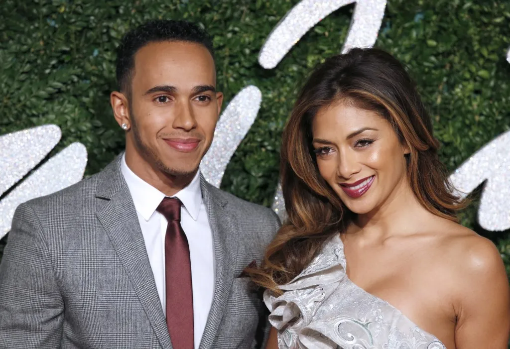 Formula One British driver Lewis Hamilton and his girlfriend US musician Nicole Scherzinger pose for pictures on the red carpet upon arrival to attend the British Fashion Awards 2014 in London on December 1, 2014. AFP PHOTO/JUSTIN TALLIS (Photo by Justin TALLIS / AFP)