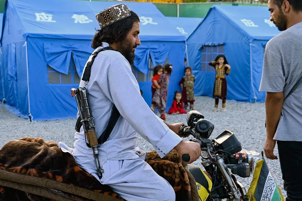 A Taliban security personnel rides a motorcycle at a makeshift camp set-up for Afghan refugees deported from Iran, in Kabul on July 16, 2025. Three million Afghans could return to their country this year, a UN refugee official said July 11, warning that the repatriation flow is placing intense pressure on an already major humanitarian crisis. (Photo by Wakil KOHSAR / AFP)
