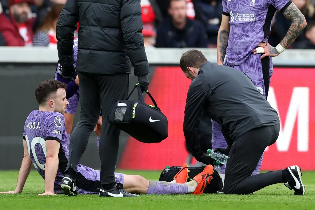 Liverpool's Portuguese striker #20 Diogo Jota is treated by medical staff after picking up an injury during the English Premier League football match between Brentford and Liverpool at the Gtech Community Stadium in London on February 17, 2024. (Photo by Adrian DENNIS / AFP) / RESTRICTED TO EDITORIAL USE. No use with unauthorized audio, video, data, fixture lists, club/league logos or 'live' services. Online in-match use limited to 120 images. An additional 40 images may be used in extra time. No video emulation. Social media in-match use limited to 120 images. An additional 40 images may be used in extra time. No use in betting publications, games or single club/league/player publications. / 