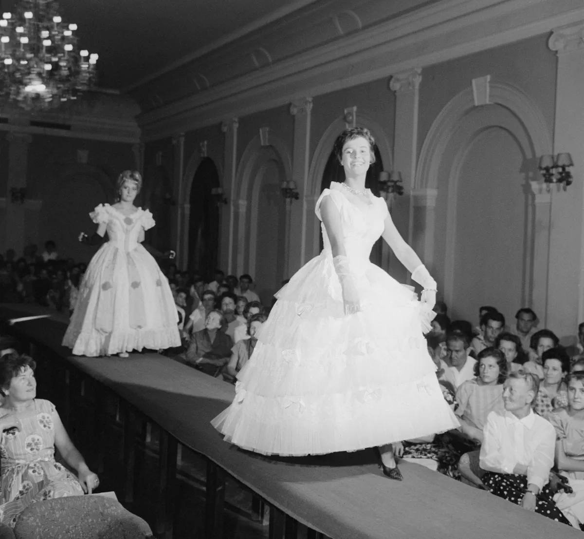 Balatonfüred, 1962. július 21.
Az 1850-es évek hangulatát idéző báli ruhát mutatnak be a manökenek a Jelmezkölcsönző Vállalatnak a 137 év Anna-báljainak divatját felvonultató bemutatóján egy héttel a hagyományos bál előtt, az Árkád SZOT Hotel nagytermében.
MTI Fotó: Friedmann Endre