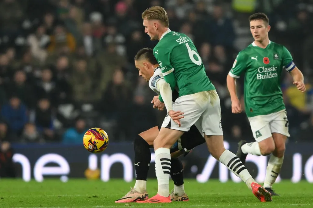 öngól Jerry Yates of Derby County shields the ball from Kornel Szucs of Plymouth Argyle during the Sky Bet Championship match between Derby County and Plymouth Argyle at Pride Park in Derby, England, on November 9, 2024. (Photo by MI News/NurPhoto) (Photo by MI News / NurPhoto via AFP)
