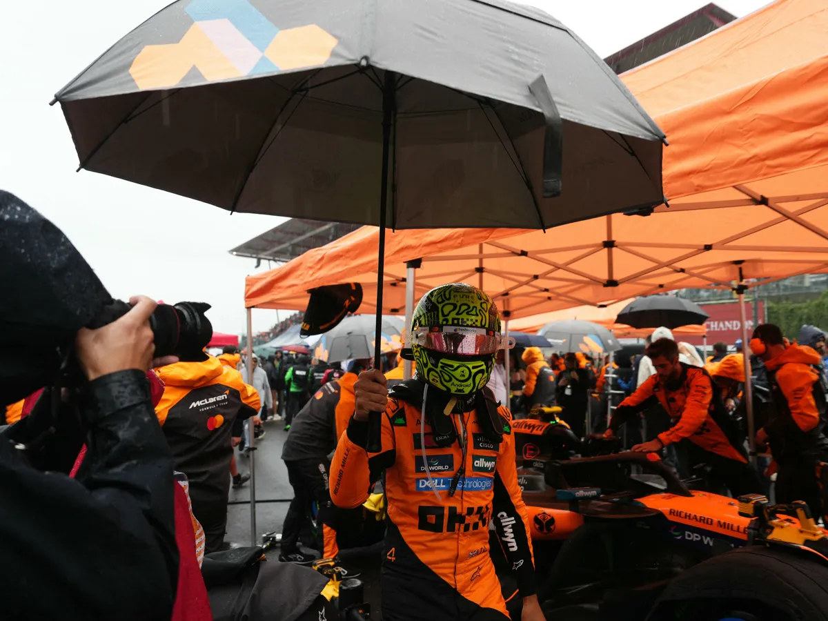 Belga Nagydíj, McLaren's British driver Lando Norris shelters from the rain under an umbrella on the grid before the start of the Formula One Belgian Grand Prix at the Spa-Francorchamps circuit in Spa, on July 27, 2025. (Photo by Dimitar DILKOFF / AFP)