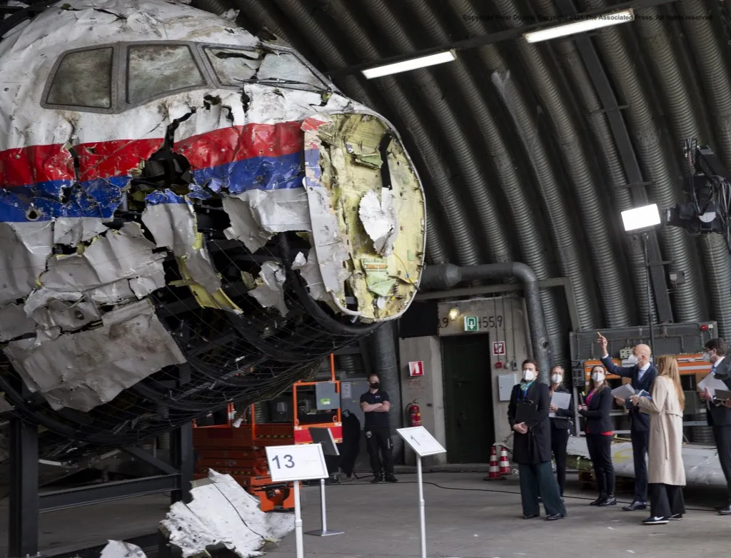 Presiding judge Hendrik Steenhuis (R) points as he and other trial judges and lawyers view the reconstructed wreckage of Malaysia Airlines Flight MH17, at the Gilze-Rijen military airbase, southern Netherlands, on May 26, 2021. Judges inspect wreckage of flight MH17 as part of criminal trial of four suspects. (Photo by Peter Dejong / POOL / AFP)
