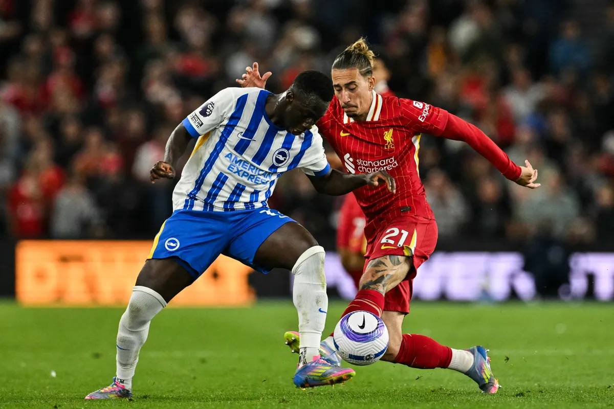Brighton's Gambian midfielder #17 Yankuba Minteh (L) fights for the ball with Liverpool's Greek defender #21 Kostas Tsimikas during the English Premier League football match between Brighton and Hove Albion and Liverpool at the American Express Community Stadium in Brighton, southern England on May 19, 2025. (Photo by Glyn KIRK / AFP) / RESTRICTED TO EDITORIAL USE. No use with unauthorized audio, video, data, fixture lists, club/league logos or 'live' services. Online in-match use limited to 120 images. An additional 40 images may be used in extra time. No video emulation. Social media in-match use limited to 120 images. An additional 40 images may be used in extra time. No use in betting publications, games or single club/league/player publications. / 