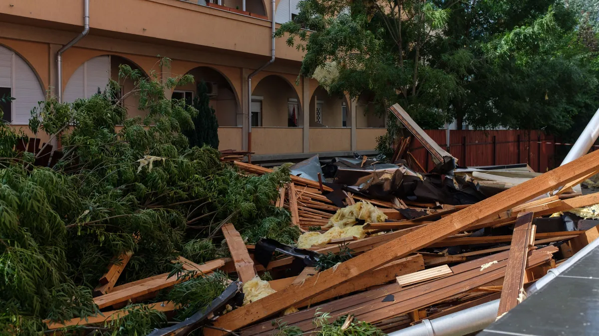 Szeged, 2025. július 8.
A Szegedi Tudományegyetem újszegedi telephelye tetőszerkezetének szétszóródott darabjai az épület közelében lévő lakóházaknál 2025. július 8-án. A vihar előző nap leszakította az átalakítás miatt üresen álló épület tetejét.
MTI/Oláh Tamás