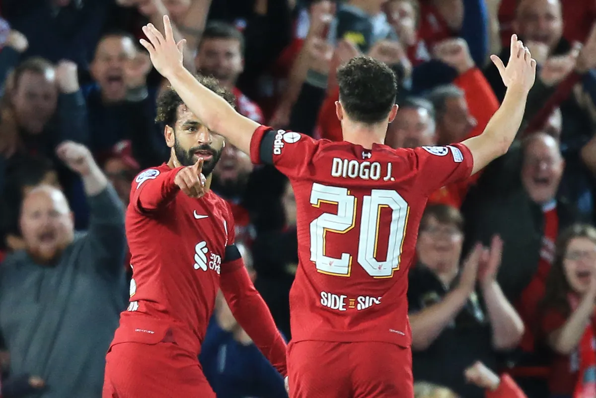 Liverpool's Egyptian striker Mohamed Szalah (L) celebrates scoring his team's first goal with Liverpool's Portuguese striker Diogo Jota (back) during the UEFA Champions League group A football match between Liverpool and Ajax at Anfield in Liverpool, north west England on September 13, 2022. (Photo by Lindsey Parnaby / AFP)
