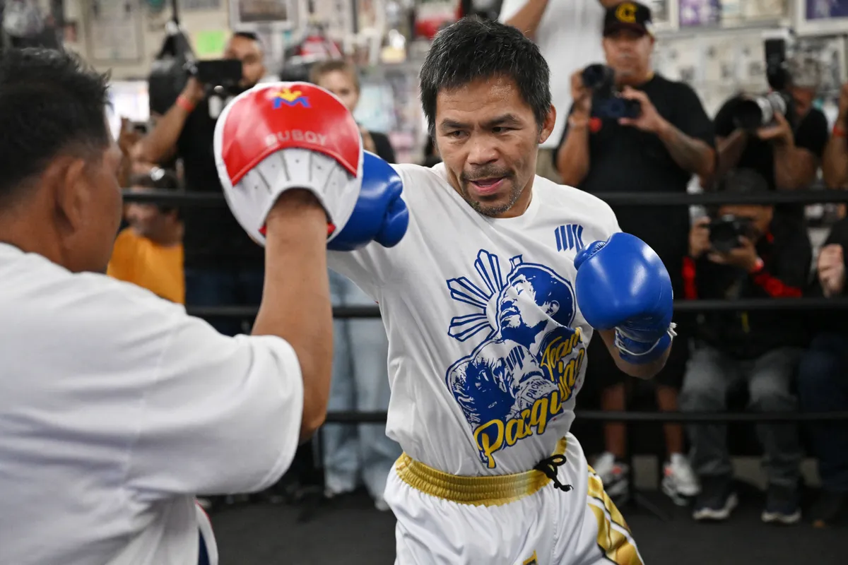 Fillipino boxer Manny "Pacman" Pacquiao (R) spars with one of his trainers during a media day workout at Wild Card Boxing Club in Los Angeles on June 25, 2025. Manny Pacquiao will take on US boxer Mario "El Azteca" Barrios for the WBC welterweight title on July 19, 2025, in Las Vegas, Nevada. (Photo by Robyn Beck / AFP)