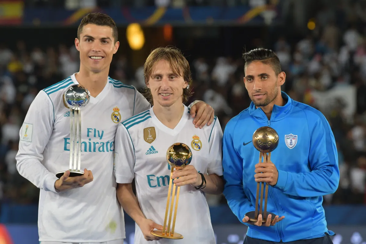 (L to R) Real Madrid's Portuguese forward Ronaldo, Real Madrid's Croatian midfielder Luka Modric and Pachuca's Uruguayan winger Jonathan Urretaviscaya pose with the 2017 FIFA Club World Cup Silver, gold and bronze awards respectively following the Club World Cup final football match against Gremio at Zayed Sports City Stadium in the Emirati capital Abu Dhabi on December 16, 2017. Real Madrid defeated Gremio 1-0 to lift the FIFA Club World Cup for the third time in their history. (Photo by Giuseppe CACACE / AFP)