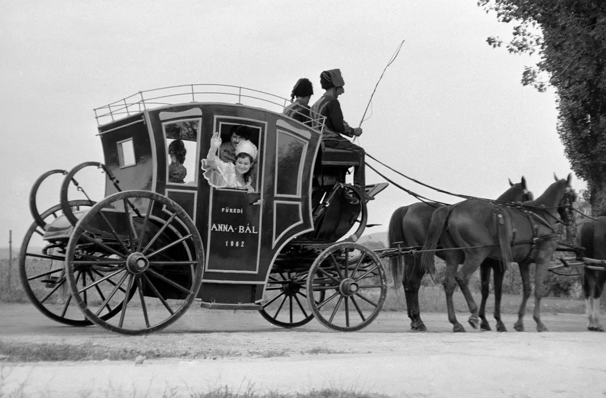 Balatonfüred, 1962. július 29.
Egy korhű jelmezbe öltözött utas integet a Postamúzeum régi delizsánszának ablakából, amely a város utcáit járva népszerűsíti a Füredi Annabált.
MTI Fotó: Járai Rudolf