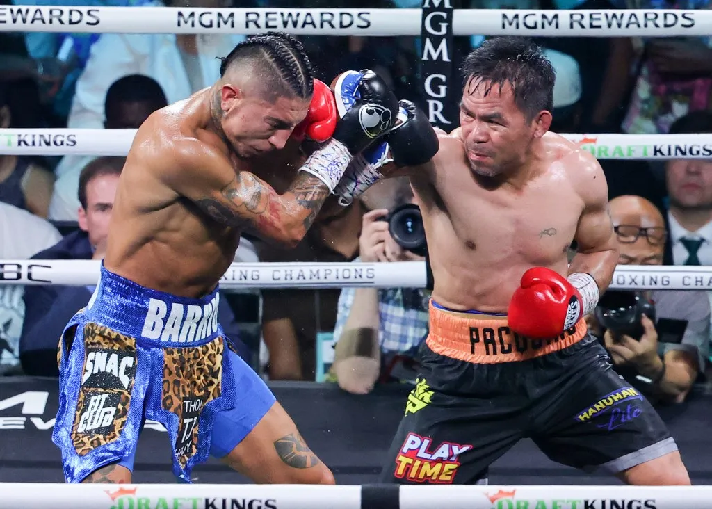 LAS VEGAS, NEVADA - JULY 19: Manny Pacquiao (R) throws a right at Mario Barrios in the seventh round of their WBC welterweight title fight at MGM Grand Garden Arena on July 19, 2025 in Las Vegas, Nevada. The fight was declared a majority draw and Barrios retained his title.   Ethan Miller/Getty Images/AFP (Photo by Ethan Miller / GETTY IMAGES NORTH AMERICA / Getty Images via AFP)