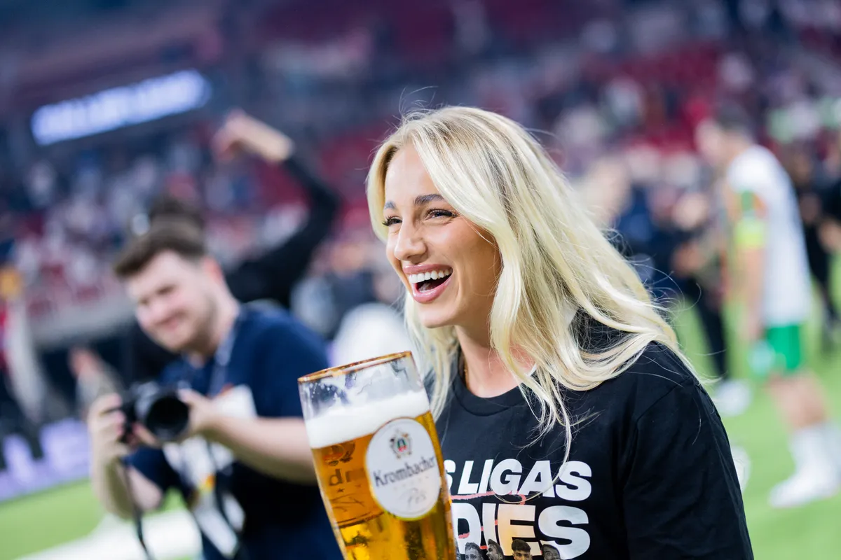 07 October 2024, North Rhine-Westphalia, Duesseldorf: Soccer: Baller League, Final Four, PSD Bank Dome: Ana Maria Markovic, team manager of Las Ligas Ladies, celebrates the victory in the final against the Gönrgy Allstars with a large glass of beer. Photo: Rolf Vennenbernd/dpa (Photo by ROLF VENNENBERND / dpa Picture-Alliance via AFP), gyönyörű focistalány