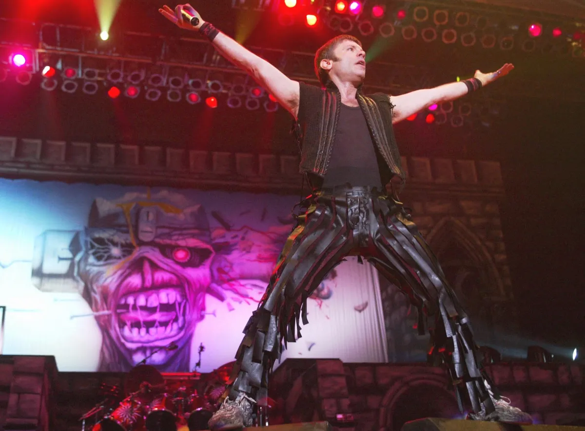 Bruce Dickinson of British Heavy Metal Band 'Iron Maiden' performs on stage at Munich's Olympiahalle 24 October 2003. The act is the opening concert of 'Iron Maiden's' German tour which is part of the band's 'Dance of Death' World Tour. The European part of the 'Dance of Death' World Tour started in Debrecen, Hungary 19 October 2003 and will end 16 December 2003 in Birmingham, UK. After Christmas the tour will continue through mid-March taking in South America, North America, Japan and other areas. (Photo by TIMM SCHAMBERGER / ddp images via AFP)