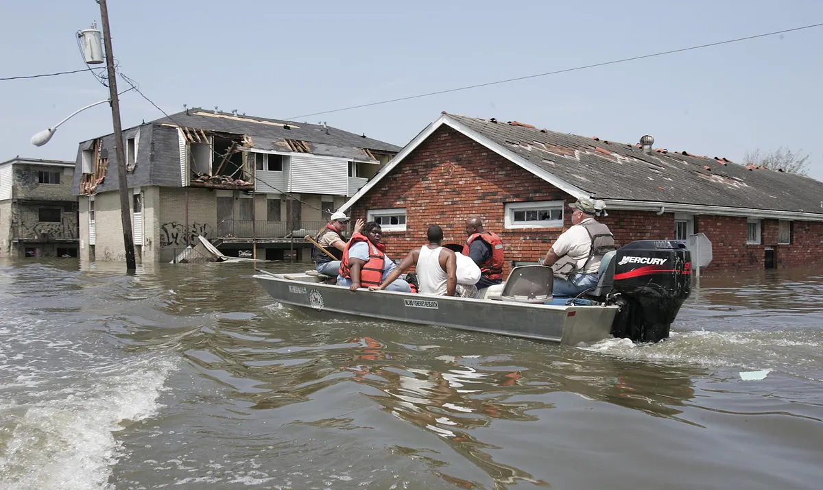 Residents are rescued amid flood waters 30 August 2005 in New Orleans, Louisiana, following Hurricane Katrina. Hurricane-battered New Orleans was consumed by a catastrophe of unimagined scale Tuesday, cut off from the outside world, submerged by rising floodwaters and troubled by signs of fraying public order. AFP PHOTO / James NIELSEN (Photo by JAMES NIELSEN / AFP)