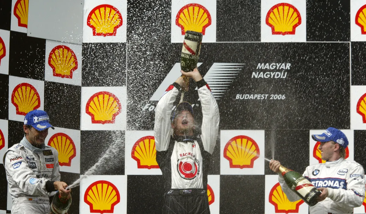 hungaroring (L to R)  Spanish McLaren-Mercedes driver Pedro de la Rosa, British Honda driver Jenson Button and  German BMW Sauber driver Nick Heidfeld spray champagne on the podium of the Hungaroring racetrack after the Hungarian Grand Prix, 06 August 2006, in Budapest. Button won the race ahead of de la Rosa and Heidfeld. AFP PHOTO ATTILA KISBENEDEK (Photo by ATTILA KISBENEDEK / AFP)