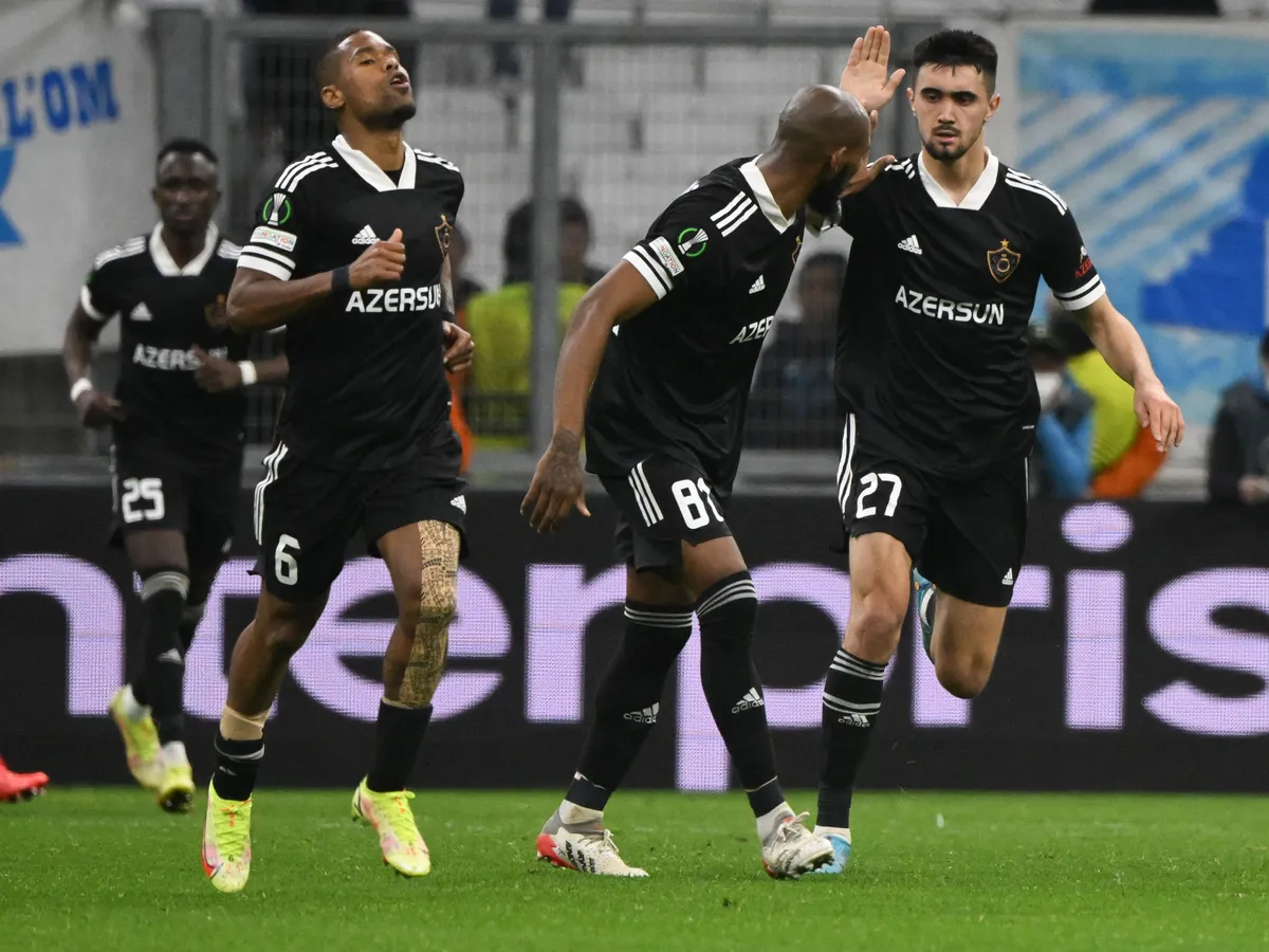 Qarabag's Azerbaijan midfielder Toral Bayramov (R) reacts with Qarabag's Colombian defender Kevin Medina (C) during the UEFA Conference Europa League round of 32 first leg football match between Olympique Marseille and Qarabag FK (AZE) at Stade Velodrome in Marseille, southern France, on February 17, 2022. (Photo by NICOLAS TUCAT / AFP)