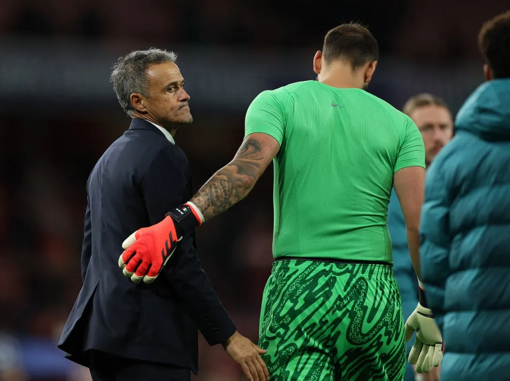 Paris Saint-Germain's Spanish coach Luis Enrique (L) consoles Paris Saint-Germain's Italian goalkeeper #01 Gianluigi Donnarumma after the UEFA Champions League football match between Arsenal and Paris Saint-Germain (PSG) at the Emirates Stadium in north London on October 1, 2024. (Photo by Adrian Dennis / AFP)