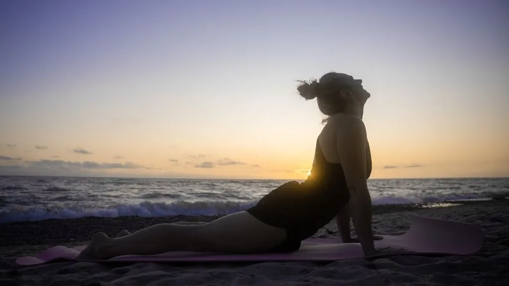 jóga A woman practices yoga during sunset on a beach near Kerkle, Lithuania on 26 July, 2025.  (Photo by Jaap Arriens/NurPhoto) (Photo by Jaap Arriens / NurPhoto via AFP)