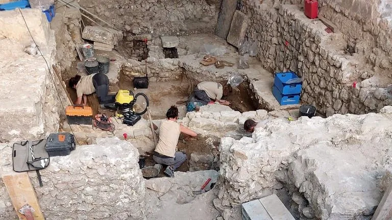 An exterior baptistery is seen in front of archaeologists working on unearthed remains of an early Christian cathedral in Vence, southeastern France on July 31, 2025. (Photo by Vincent-Xavier MORVAN / AFP), régész
