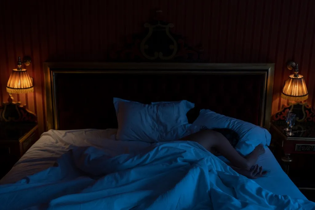 Unrecognizable person sleeping in bed (Photo by Frédéric Cirou / AltoPress / PhotoAlto via AFP)
