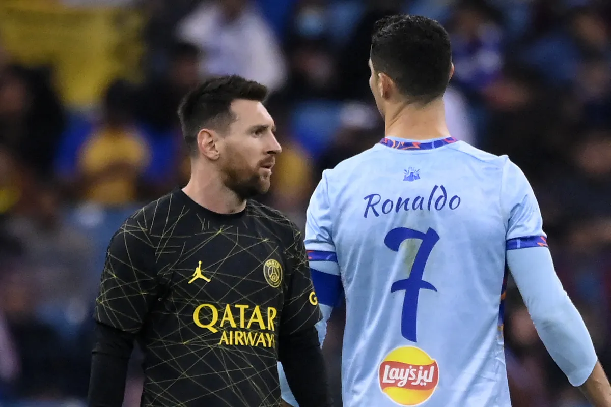 Paris Saint-Germain's Argentine forward Lionel Messi (L) walks past Riyadh All-Star's Portuguese forward Cristiano Ronaldo (R) during the Riyadh Season Cup football match between the Riyadh All-Stars and Paris Saint-Germain at the King Fahd Stadium in Riyadh on January 19, 2023. (Photo by FRANCK FIFE / AFP)