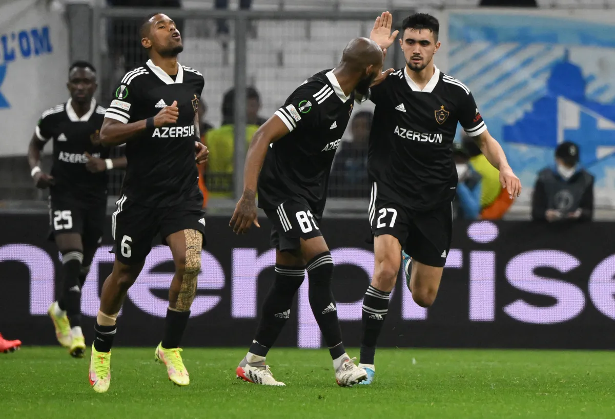Qarabag's Azerbaijan midfielder Toral Bayramov (R) reacts with Qarabag's Colombian defender Kevin Medina (C) during the UEFA Conference Europa League round of 32 first leg football match between Olympique Marseille and Qarabag FK (AZE) at Stade Velodrome in Marseille, southern France, on February 17, 2022. (Photo by NICOLAS TUCAT / AFP)