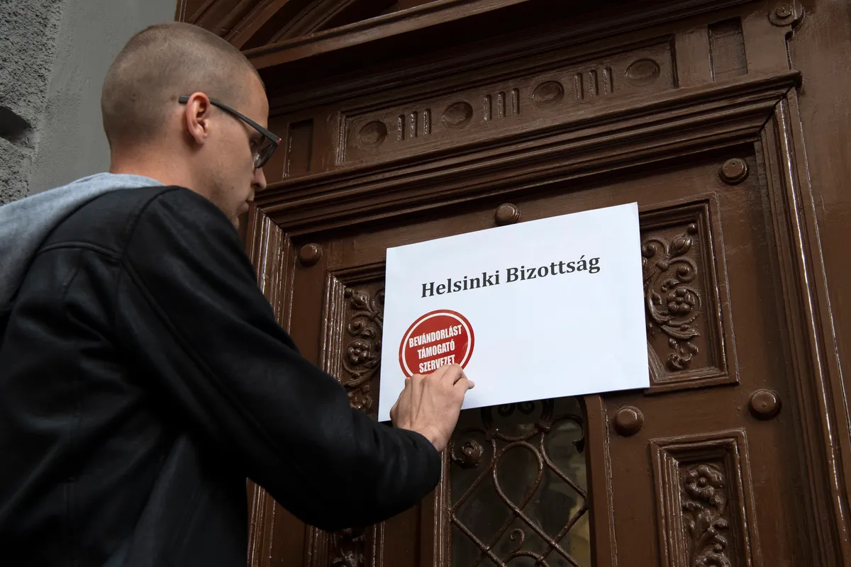 Budapest, 2018. június 27.
Falusi Vajk, a kormánypárt ifjúsági társszervezete, a Fidelitas szóvivője „Bevándorlást támogató szervezet” feliratú matricát ragaszt a bejárathoz a Magyar Helsinki Bizottság irodájának helyet adó épület előtt tartott sajtótájékoztatóján Budapesten 2018. június 27-én.
MTI Fotó: Szigetváry Zsolt