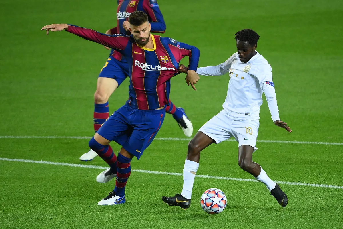 Barcelona's Spanish defender Gerard Pique (L) vies with Ferencvaros' Norwegian midfielder Tokmac Nguen during the UEFA Champions League football match between FC Barcelona and Ferencvarosi TC at the Camp Nou stadium in Barcelona on October 20, 2020. (Photo by LLUIS GENE / AFP)