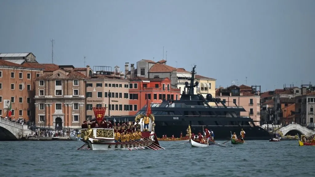 Rowers take part in the annual gondolas and boats Historical Regatta (Regata Storica) in Venice as MAIN Yacht owned by Italian designer Giorgio Armani is docked in the background,  on September 3, 2023. (Photo by GABRIEL BOUYS / AFP)
