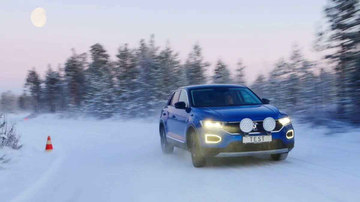 Egy Volkswagen T-Roc kanyarodik havas úton a 2025-ös téligumi-teszten.