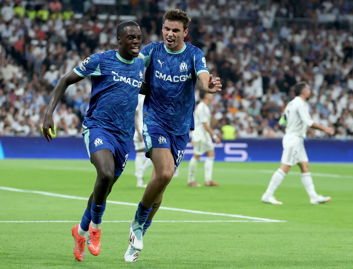 Marseille's US forward #22 Tim Weah celebrates with Marseille's Danish midfielder #17 Matthew O'Riley scoring his team's first goal during the UEFA Champions League first round day 1 football match between Real Madrid CF and Olympique de Marseille at the Santiago Bernabeu stadium in Madrid on September 16, 2025. (Photo by Thomas COEX / AFP)