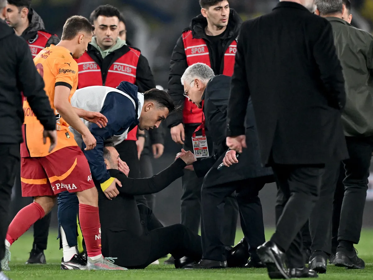 ISTANBUL, TURKIYE - APRIL 2: Okan Buruk, head coach of Galatasaray fell on the ground after his hit on the face during the Ziraat Turkish Cup Quarter-Final match between Fenerbahce and Galatasaray at Ulker Stadium in Istanbul, Turkiye on April 2, 2025. Ali Atmaca / Anadolu (Photo by ALI ATMACA / Anadolu via AFP)