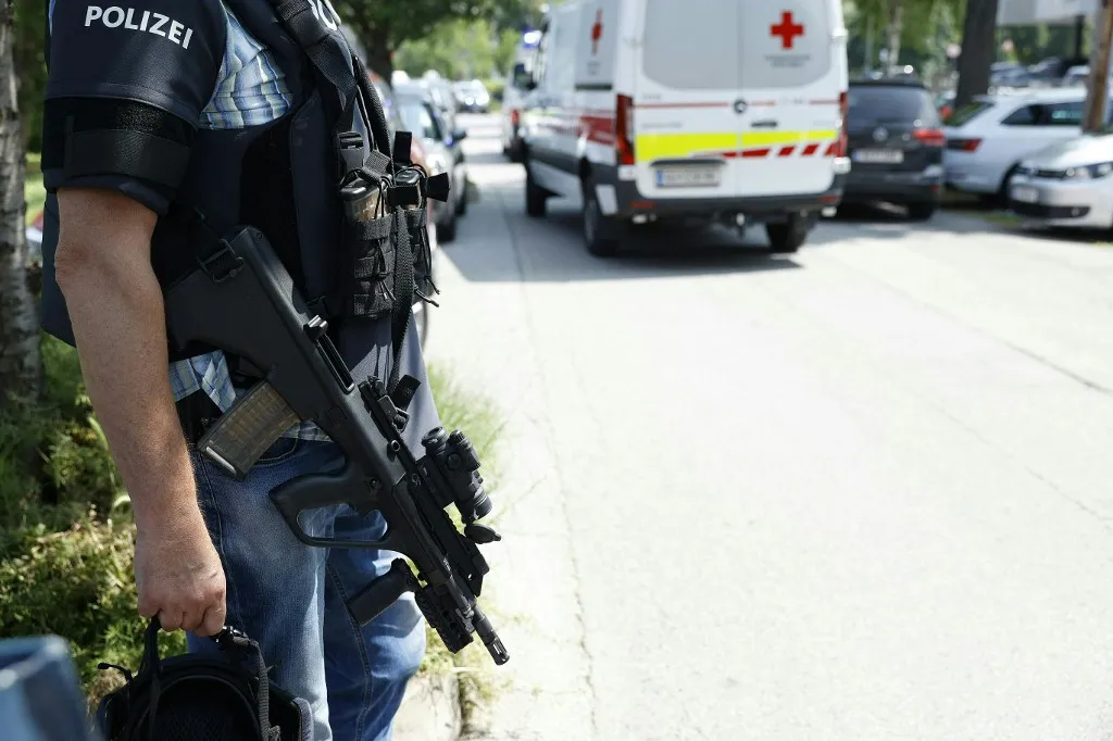 A policeman is seen next to an ambulance car close to a school where, according to reports, several people died in a shooting, on June 10, 2025 in Graz, southeastern Austria. Several people died in a school shooting, including the attacker, Austrian broadcaster ORF quoted the interior ministry as saying. (Photo by ERWIN SCHERIAU / APA / AFP) / Austria OUT, bevándorló