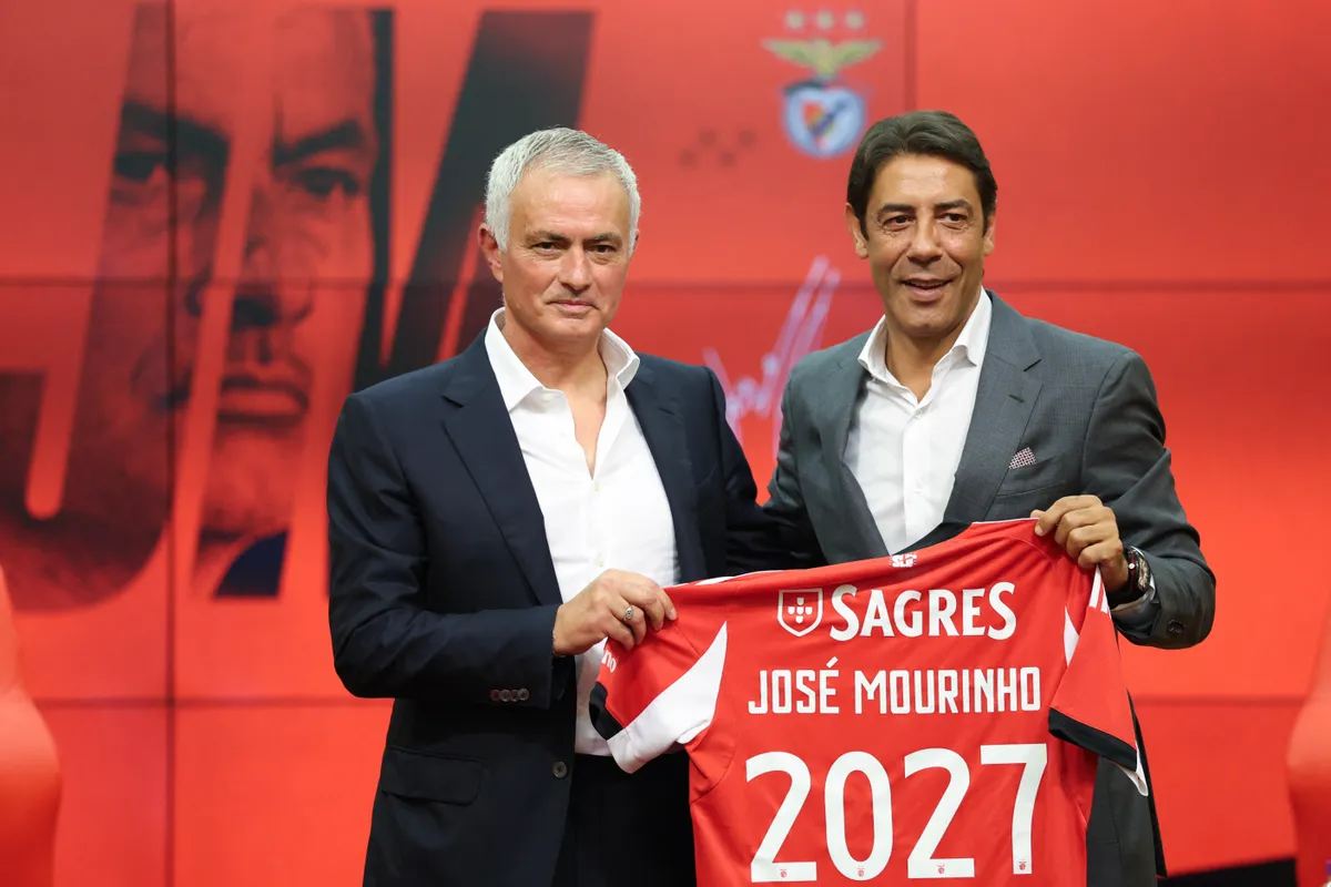 Portuguese coach Jose Mourinho (L) holds up a Benfica jersey with his name together with Benfica president Rui Costa during a press conference for his official presentation as new Benfica coach at the Benfica Campus training center in Seixal, on the outskirts of Lisbon, on September 18, 2025. Benfica sacked Portuguese coach Bruno Lage following their defeat to Qarabag on September 16, 2025 evening in the Champions League, and contacted Jose Mourinho the next day to hire him. (Photo by PATRICIA DE MELO MOREIRA / AFP)