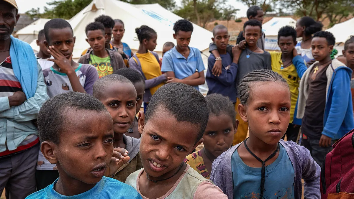 TIGRAY, ETHIOPIA - 2023/05/18: A group of children looks at the camera at the IDP (internally displaced person ) Centre 'TVET' in the city of Tigray. In 2018, Abiy Ahmed took office as Ethiopia's Prime Minister. Just a year later, he earned the Nobel Peace Prize for his role in ending a two-decade conflict with Eritrea. However, on November 3, 2020, he initiated a military offensive in the north, triggering a prolonged and violent conflict. This unexpected battle, initially intended to be swift, has persisted for two years, despite a peace deal inked in November 2022. The aftermath of this conflict is evident daily on the Tigray streets, where food scarcity is a grim reality due to the ongoing blockade. (Photo by Edgar Gutiérrez/SOPA Images/LightRocket via Getty Images)