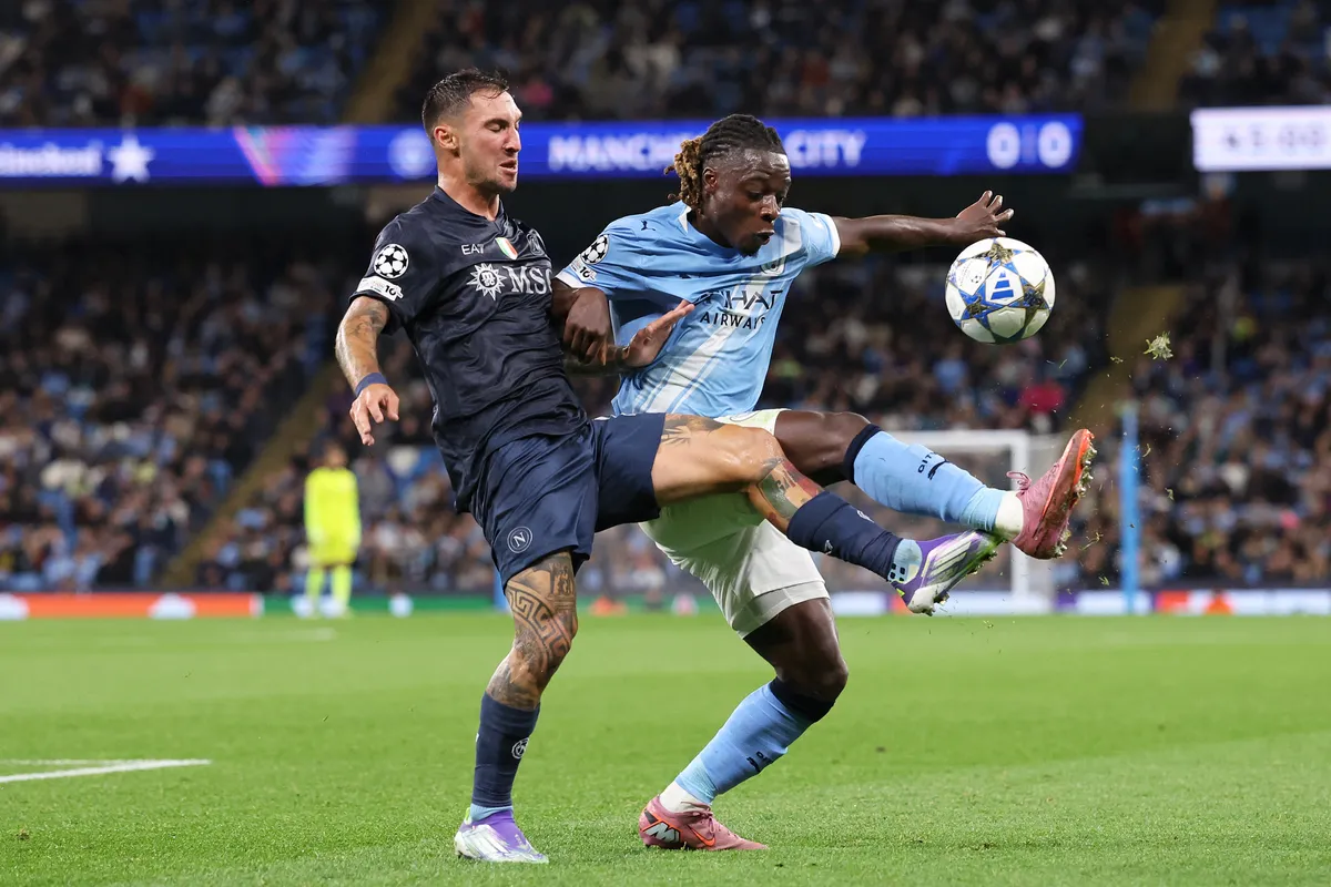 MANCHESTER, UNITED KINGDOM - SEPTEMBER 18: Jeremy Doku of Manchester City is tackled by Matteo Politano of SSC Napoli during the UEFA Champions League match between Manchester City and SSC Napoli at Etihad Stadium on September 18, 2025 in Manchester, United Kingdom. Alex Livesey / Anadolu (Photo by ALEX LIVESEY / Anadolu via AFP)