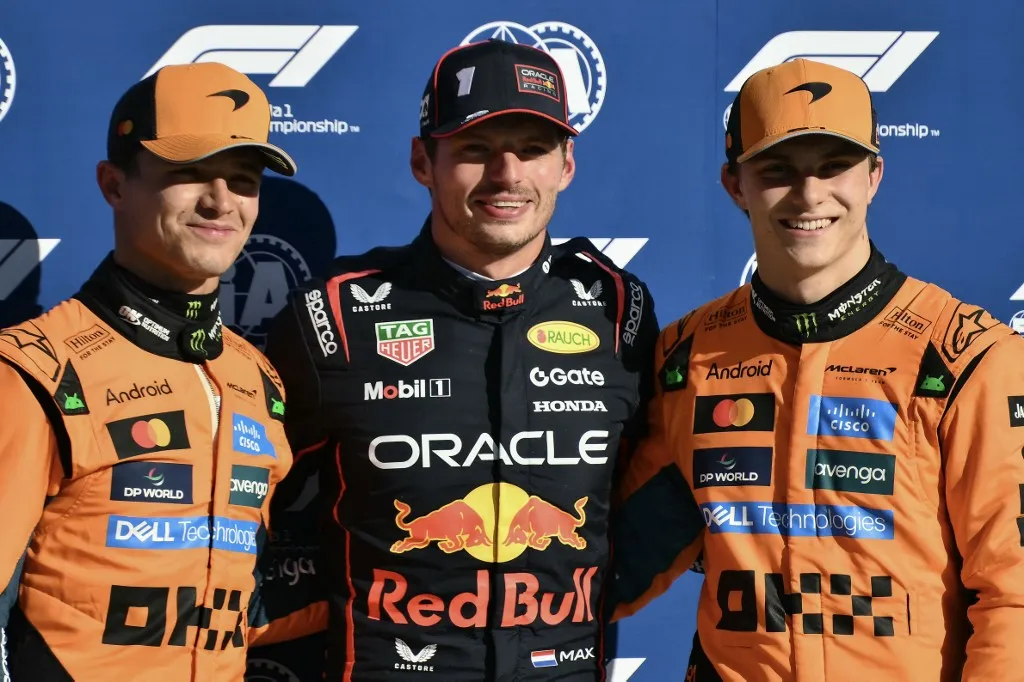 Red Bull Racing's Dutch driver Max Verstappen (C) celebrates his pole position with second placed McLaren's British driver Lando Norris (L) and third-placed McLaren's Australian driver Oscar Piastri (R) after the qualifying session ahead of the Italian Formula One Grand Prix at the Autodromo Nazionale Monza circuit, in Monza, northern Italy, on September 6, 2025. (Photo by Marco BERTORELLO / AFP)