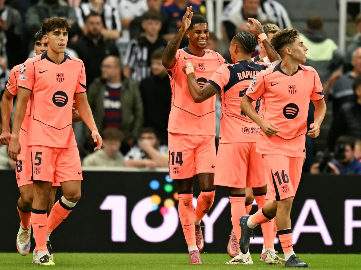 Barcelona's British forward #14 Marcus Rashford (C) celebrates with teammates after scoring his team's first goal during the UEFA Champions League first round football match between Newcastle United FC and FC Barcelona at St James' Park in London, on September 18, 2025. (Photo by Oli SCARFF / AFP)