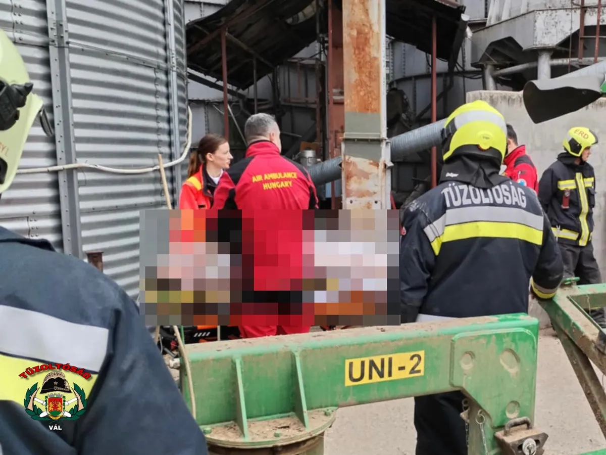 Tűzoltók küzdenek a balesetet szenvedett férfi kiszabadításáért, akinek a lábát bekapta a teherhordó csiga egy gabonasilónál, Kajászón