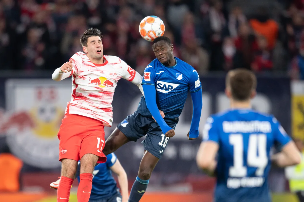 10 April 2022, Saxony, Leipzig: Soccer: Bundesliga, RB Leipzig - TSG 1899 Hoffenheim, Matchday 29, at Red Bull Arena: Leipzig's Dominik Szoboszlai (l) in a duel with Hoffenheim's Diadie Samassekou. Photo: Sebastian Kahnert/dpa - IMPORTANT NOTE: In accordance with the requirements of the DFL Deutsche Fußball Liga and the DFB Deutscher Fußball-Bund, it is prohibited to use or have used photographs taken in the stadium and/or of the match in the form of sequence pictures and/or video-like photo series. (Photo by Sebastian Kahnert / dpa Picture-Alliance via AFP)